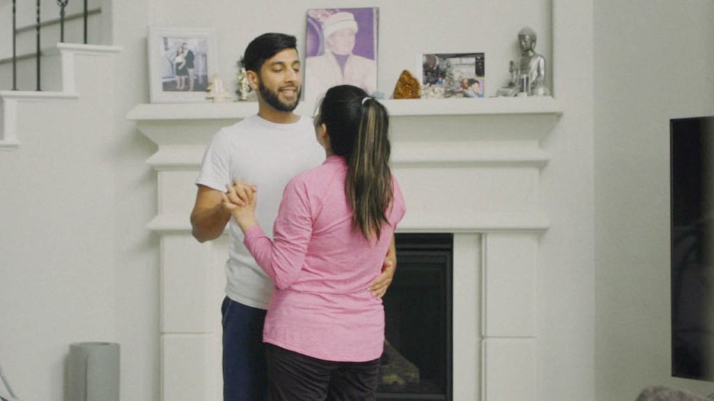 Young couple dance tango in front of living room fireplace