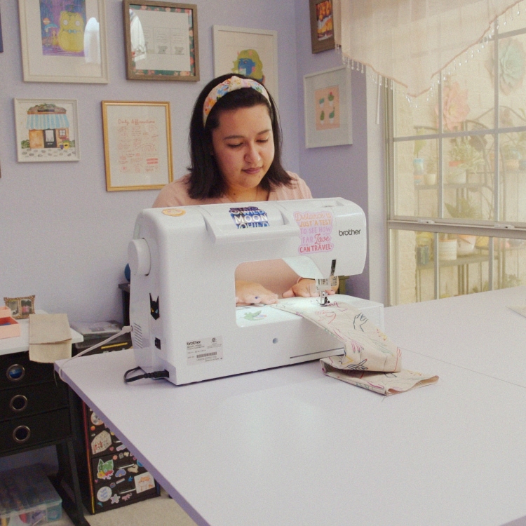 Lady sitting at her sewing machine, working on crafting something