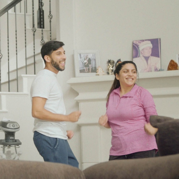 Couple smiling and laughing dancing around their living room