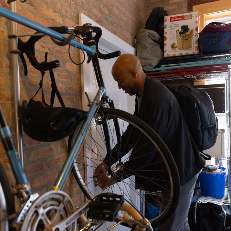 Man locking up his garage, with a bike hanging on the wall
