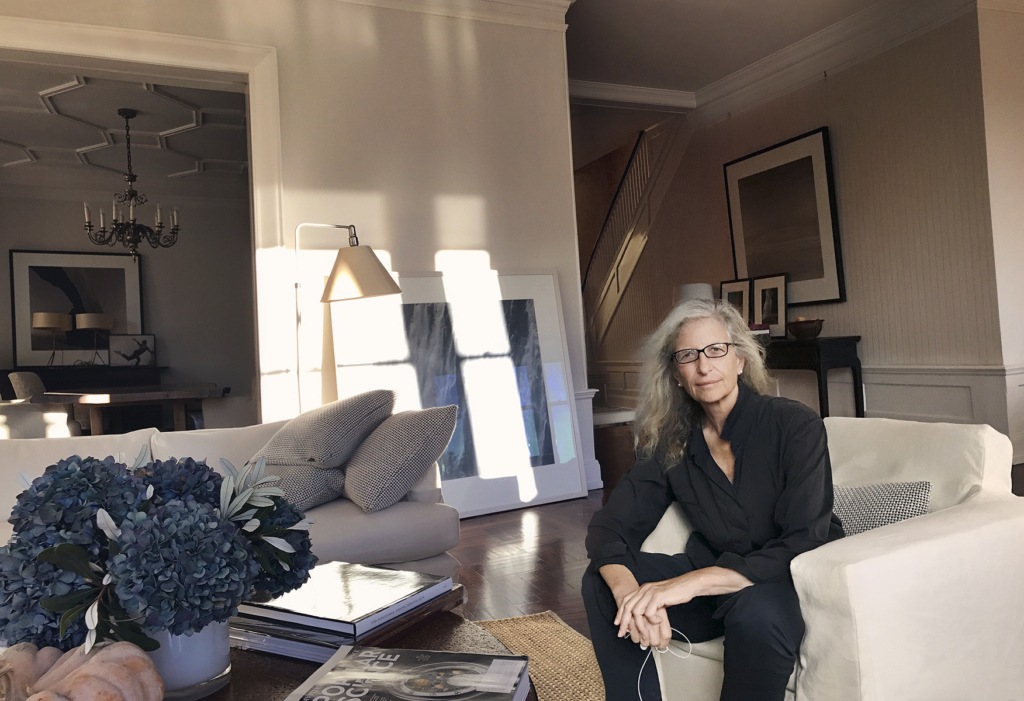Portrait of Annie Leibovitz, photographer, in her living room sitting on an armchair