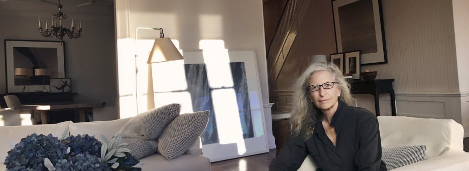 Portrait of Annie Leibovitz, photographer, in her living room sitting on an armchair