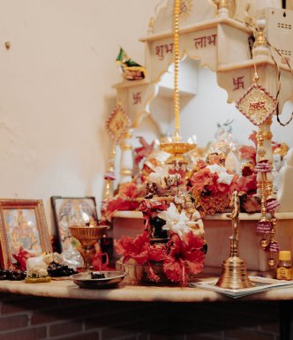 Shrine in the corner of a bedroom, with flowers, candles and a mini temple