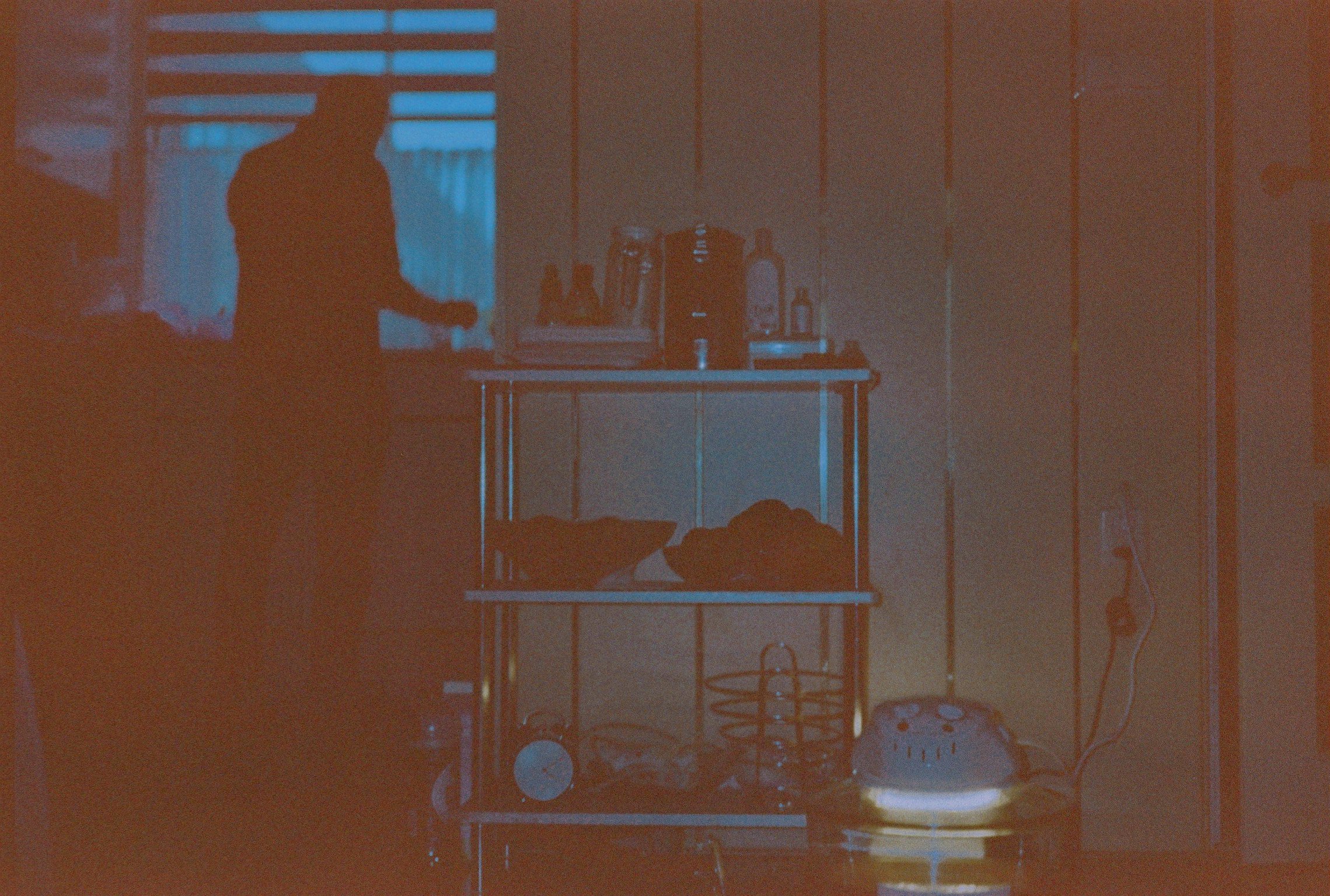 Dark photo, the silhouette of Trams father standing in the kitchen.
