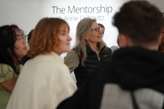Annie Leibovitz and the mentees gathered at the exhibition in front of a wall with the text: The Mentorship with Annie Leibovitz.