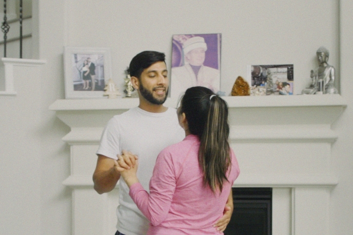 Young couple smiling and dancing in their living room