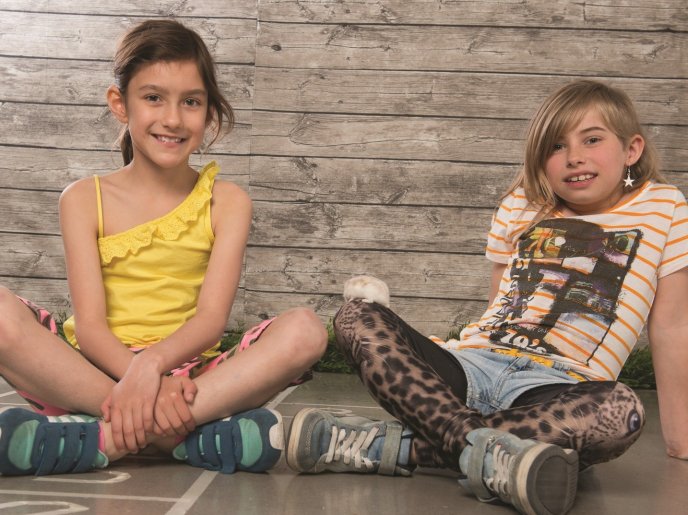two young girls sat cross-legged on the floor