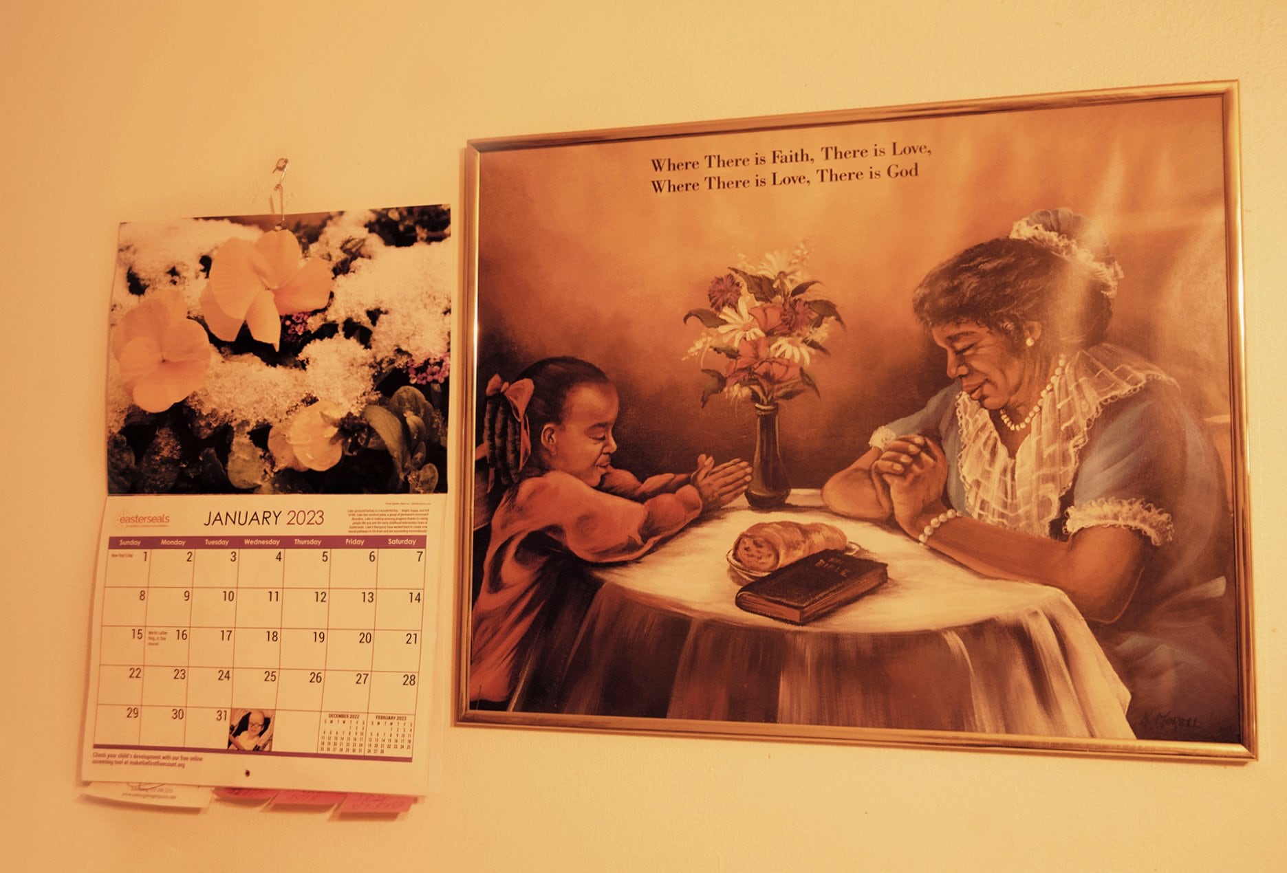 A wall calendar and a picture with a prayer,