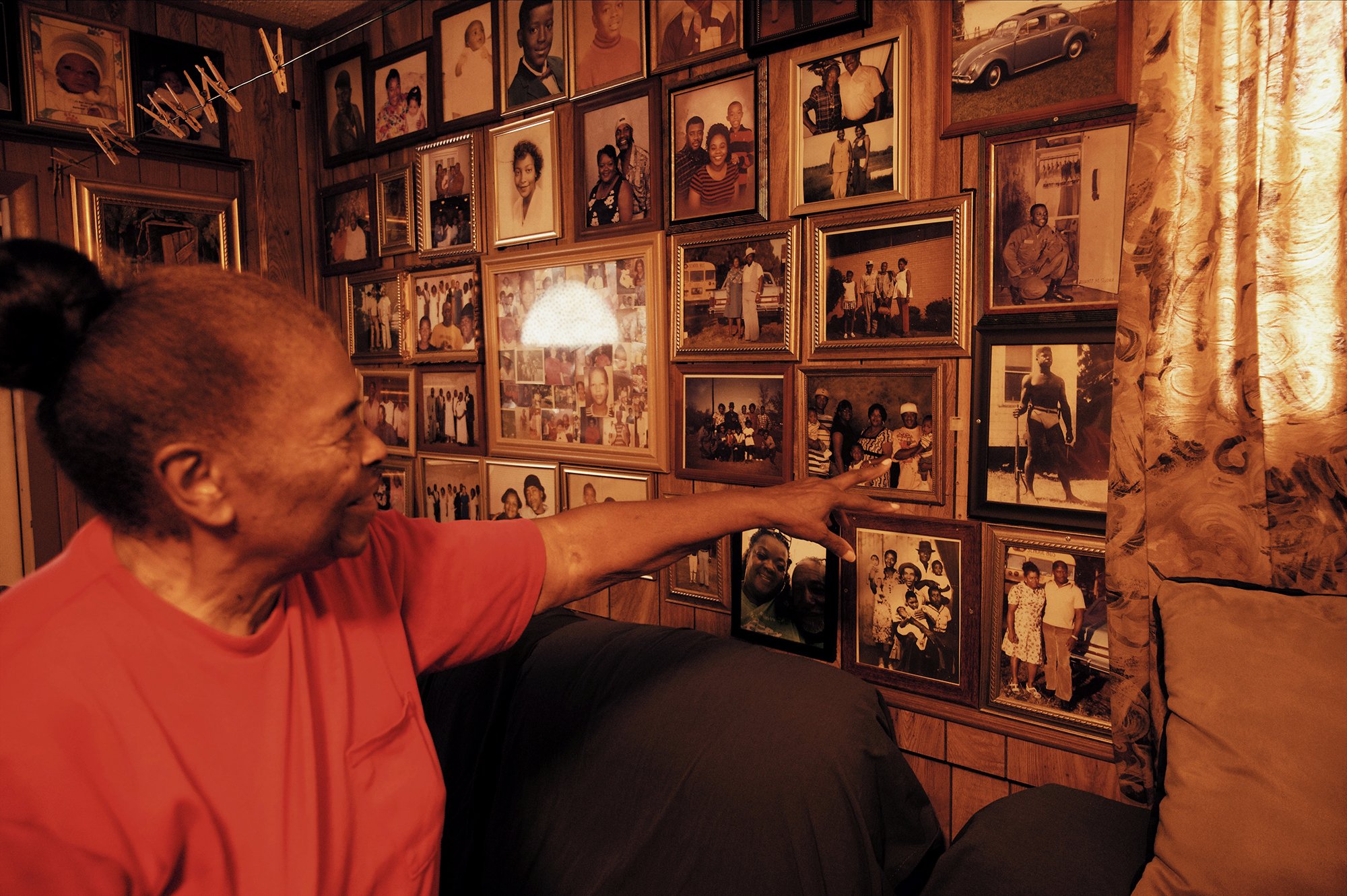 The lady pointing at one of the many family photos on the wall.